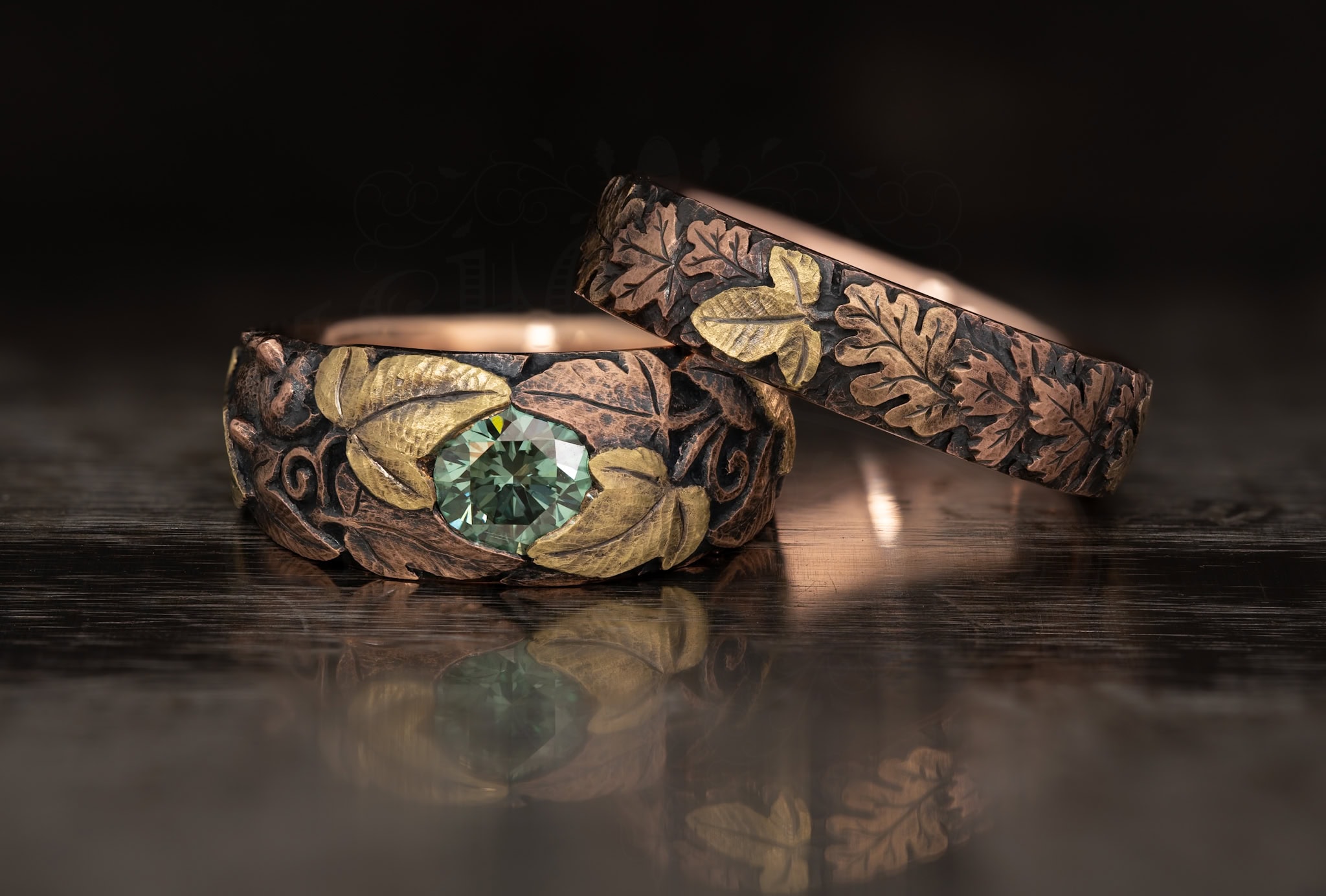 On this picture you see a wedding band pair with a hand engraved superficie and a green diamonds. this work was made by andrew ashcroft